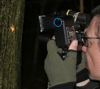 Troells Melgaard ved at fotografere en frostmåler, der er på toppen af kamereaet et hjælpelys, samt en ekstern flash med ledning som kan vinkles på motivet efter behov. Raadvad 16 marts 2005. Fotograf: Lars Andersen
